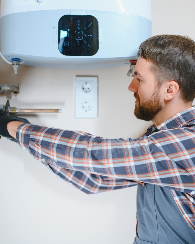 worker set up central gas heating boiler at home.